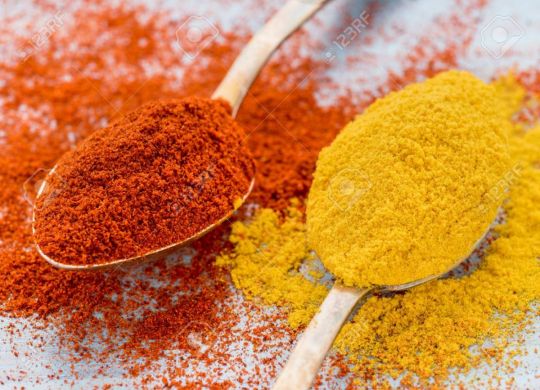 93189371-two-heaping-scoops-of-spices-of-paprika-powder-and-turmeric-curry-powder-scattered-on-the-wooden-blu (1)