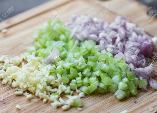 Cooking dinner, chopped vegetables onions, garlic, celery on desk
